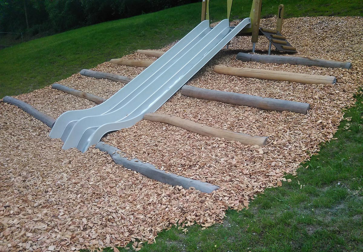 Foto von der Doppelrutsche mit Holzbalken in den Außenanlagen des Kindergartens Rosenburg in Müllheim